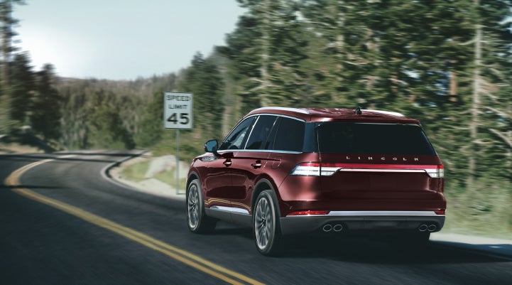 A 2024 Lincoln Aviator® SUV is being driven on a winding mountain road | Allan Vigil Lincoln, Inc. in Morrow GA