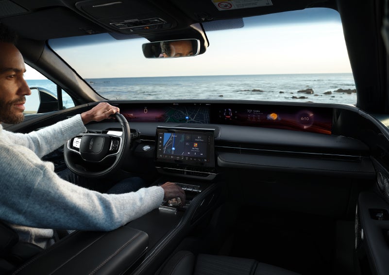 A driver of a parked 2024 Lincoln Nautilus® SUV takes a relaxing moment at a seaside overlook while inside his Nautilus. | Allan Vigil Lincoln, Inc. in Morrow GA
